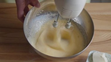 Yumurtaları kremalı köpüğe karıştırıyorum.
