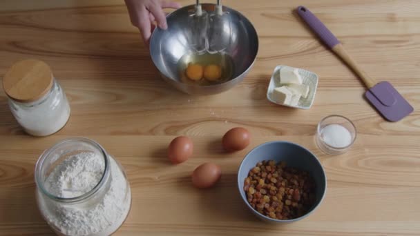 Женщина смешивает яйца с электрическим миксером — стоковое видео