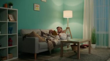 Genç adam kitapla rahatlıyor.