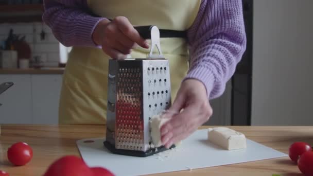 Γυναίκα σε κίτρινο Apron τρίβει το τυρί — Αρχείο Βίντεο