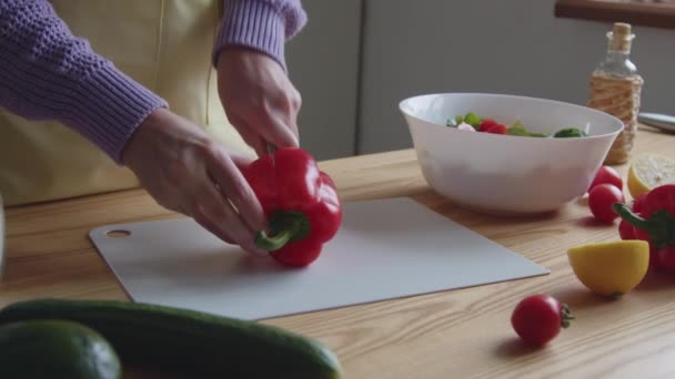 Mujer está cortando pimiento dulce rojo — Vídeo de stock
