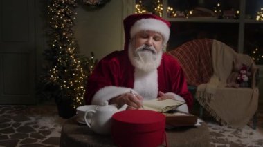 Noel Baba evinde çalışıyor, bazı notlar alıyor, Noel 'e hazırlanıyor, Ağır çekim..