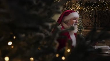 Meşgul Noel Baba Noel sezonuna hazırlanıyor, evinde çalışıyor, yazışmalarla uğraşıyor, çocukların mektuplarını zevkle okuyor, ağır çekimde....