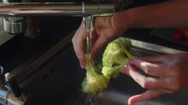 Kadın yemek için taze brokoli, lezzetli organik sebze, evde sağlıklı yemek pişirme, ev mutfağı, yakın çekim, yavaş çekim..