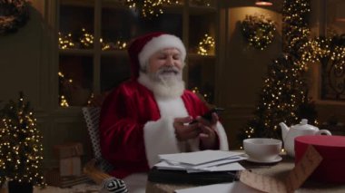 Noel Baba arka bahçede oturuyor ve cep telefonundan konuşuyor. Tatil öncesi bazı ayarlamalar yapıyor. Yoğun tatil sezonu..