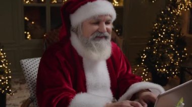 Mutlu Noel Baba evinde çalışıyor, tatillere hazırlanıyor, dizüstü bilgisayara bir mektup yazıyor, kapat, ağır çekim..