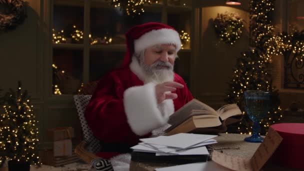 Julemanden Sidder Baghaven Nyder Hyggelig Vinteraften Kigger Gennem Sin Opslagsbog – Stock-video