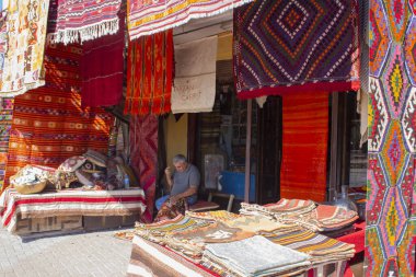 Bergama, İzmir, Türkiye - 10.2022: Geleneksel halı dikme adamı, geleneksel dükkanının önünde el yapımı halı ören adam, 
