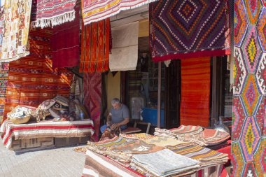 Geleneksel dükkanının önünde el yapımı halı ören adam, geleneksel halı dikişçisi.