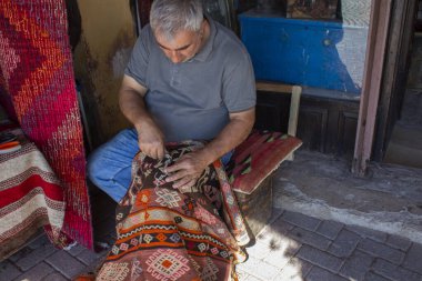 Bergama, İzmir, Türkiye - 10.2022: Halı dokumacı adam, geleneksel el yapımı halı 