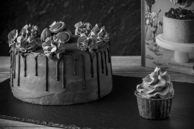 Kremalı ve dutlu lezzetli kekler ve koyu taşlı arka plan.