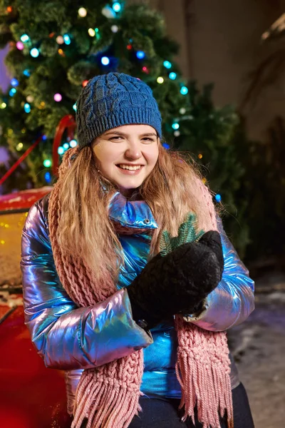 Eşarplı, şapkalı, ceketli, eldivenli, kışın dışarıda gülümseyen beyaz bir kadın. Yeni yıl, eğlence, kış konsepti