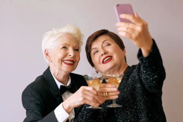 Две Красивые Стильные Зрелые Пожилые Женщины Пьют Вино Делают Селфи — стоковое фото