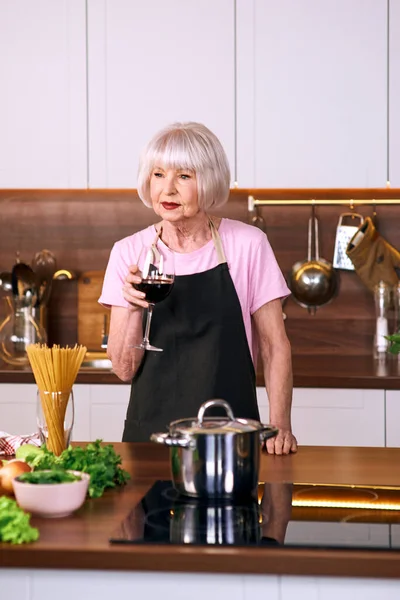 Donna Allegra Più Anziana Sta Bevendo Vino Rosso Durante Cottura — Foto Stock