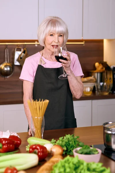 Donna Allegra Più Anziana Sta Bevendo Vino Rosso Durante Cottura — Foto Stock