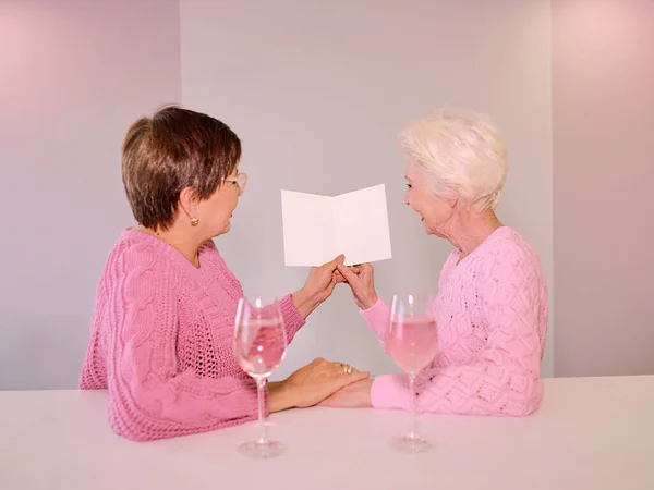 Dos Mujeres Maduras Bebiendo Vino Dando Una Postal Amistad Vacaciones — Foto de Stock