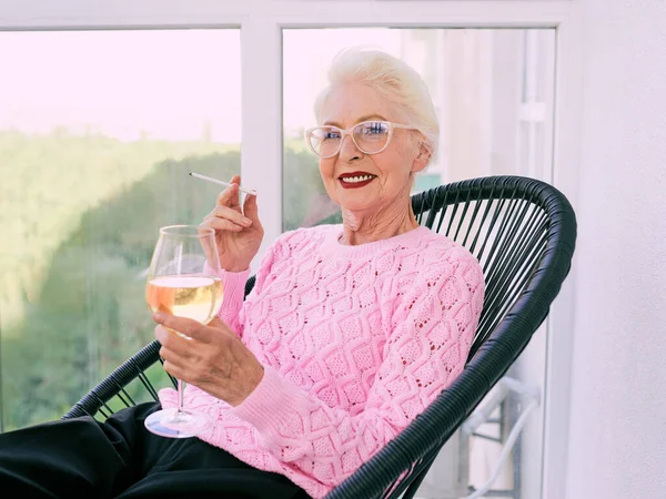 Старомодная Пожилая Стильная Женщина Сидящая Террасе Курящая Сигарету Бокалом Белого — стоковое фото