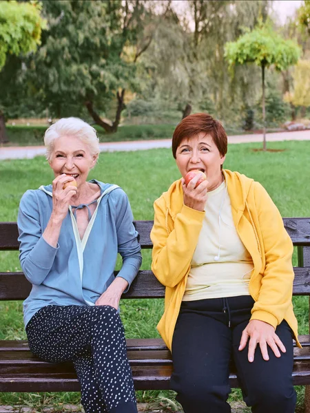 Dos Mujeres Maduras Comiendo Manzanas Banco Después Hacer Ejercicios Deportivos —  Fotos de Stock