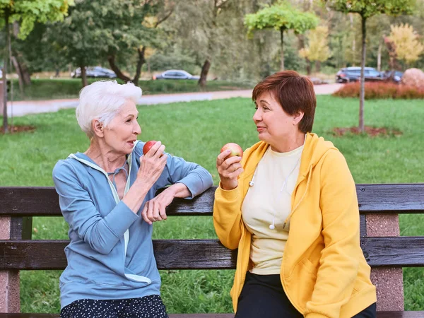Duas Mulheres Maduras Comendo Maçãs Banco Depois Fazer Exercícios Esportivos — Fotografia de Stock