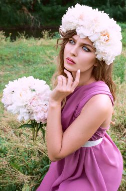 Kafkasyalı güzel bir kadın kafasında beyaz şakayık çelengi var. Bahar, çiçek, peri konsepti.