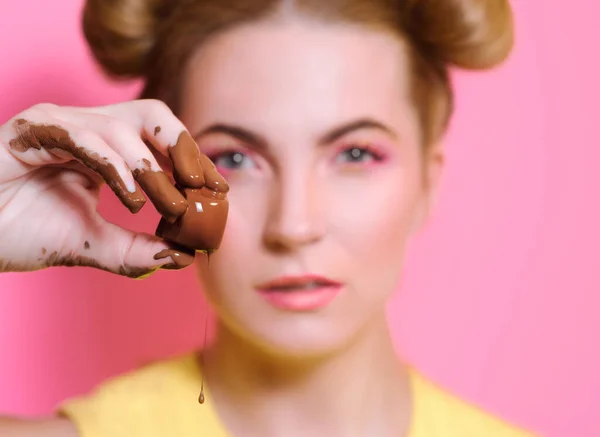 손가락에 초콜릿 사탕을 귀엽고 매력적 금발의 여자의 — 스톡 사진