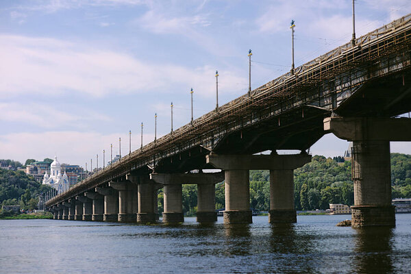 KYIV, UKRAINE - SEPTEMBER 2, 2020: Cityscape from the water to Patona's bridge and church