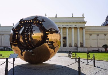 Vatican, Italy - October 16, 2021: View of courtyard of the Pigna and sculpture Sfera con Sfera, Arnaldo Pomodoro. Sfera di Pomodoro