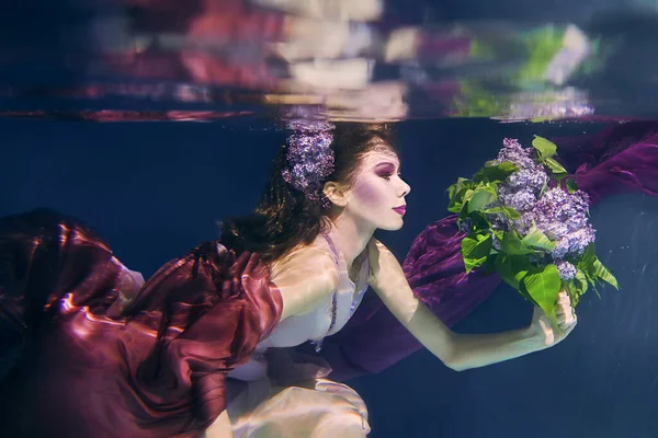 Женщина Лиловым Букетом Красочной Одежде Темном Фоне Плавает Водой — стоковое фото