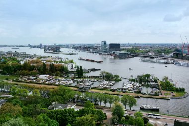 Amsterdam, Hollanda - 28 Nisan 2019: Şehir manzarası bulutlu bir Hollanda gününde yukarıdan şehrin merkezi bölümü, feribot ve kanal.