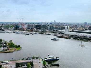 Amsterdam, Hollanda - 28 Nisan 2019: Şehir manzarası bulutlu bir Hollanda gününde yukarıdan şehrin merkezi bölümü, feribot ve kanal.