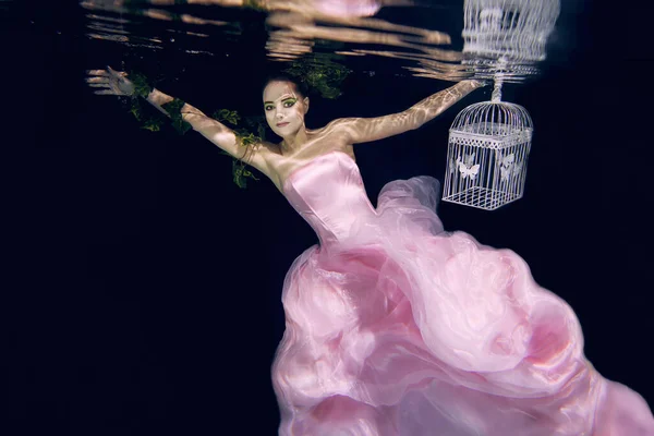 Молода Красива Жінка Довгій Рожевій Сукні Кліткою Руках Під Водою — стокове фото