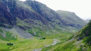 Glen Coe, İskoçya tepelerinden geçen bir yolun insansız hava aracı görüntüsü..