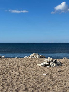 Kapalı deniz kumsalı. Renkli altın rengi günbatımı gökyüzü sakinlik, dinlendirici güneş ışığı yaz titreşimleri, sakin deniz. Sahilde gün batımı. Meditasyon okyanusu ve gökyüzü arka planı. Suyun üzerinde ufuk.. 