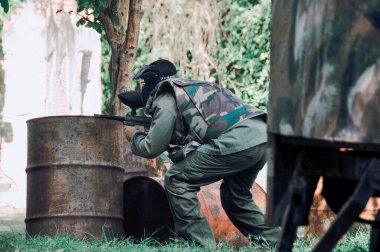 Paintball oynayan bir adam hedefine nişan alır.