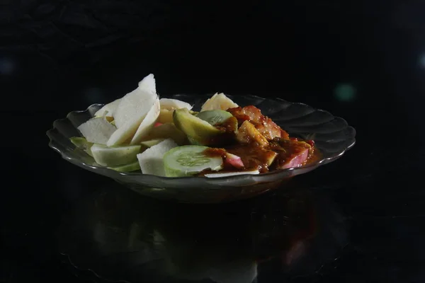 Kırmızı Biberli Meyve Salatası Siyah Arka Planlı Bir Tabakta Esmer — Stok fotoğraf