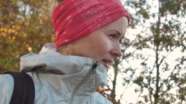 森の中で一人で彼女の頭の上にスカーフを持つ美しい白い女性は カメラで笑顔 — ストック動画