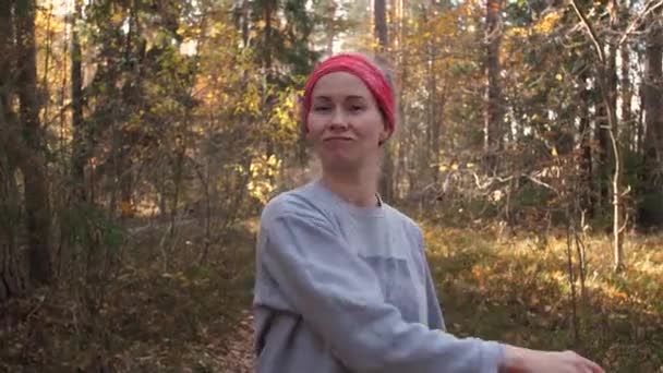 森林里的一个女人摘下一顶眼镜片跳过她的头发 在树林里呼吸着新鲜空气 感到很快乐 — 图库视频影像