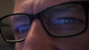 Yatırımcı kripto para çizelgesine uyuyor. Bir adamın gözündeki grafiğin yansıması. Şifreli para çizelgesi olan bir tabletin yansıması. Yumuşak odak videosu