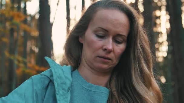 一个长头发的女人站在树林里 打开一瓶水 — 图库视频影像