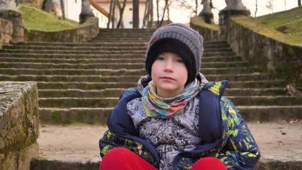 Oğlan Sonbahar Boyunca Parkta Büyük Bir Merdivende Oturur — Stok video