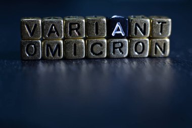 SARS-CoV-2 Coronavirus Varyant Omicron. OMICRON ismi ortaya çıktı. Kırmızı ve siyah arkaplan.