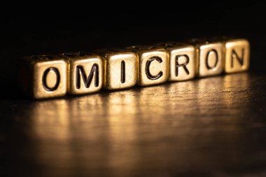 SARS-CoV-2 Coronavirus Varyant Omicron. OMICRON ismi ortaya çıktı. Kırmızı ve siyah arkaplan.
