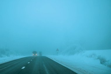 Akşamları sisli yol. Kış asfalt yolu bulanıklaştı. Bulanık fotoğraf