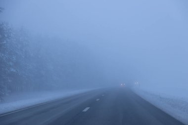 Akşamları sisli yol. Kış asfalt yolu bulanıklaştı. Bulanık fotoğraf