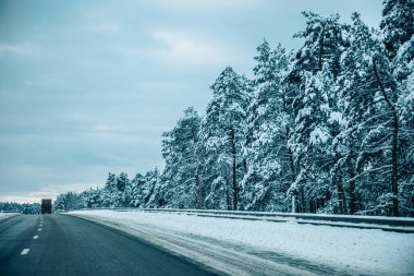 Kış asfalt yolu. Kış yolu, kar ve Letonya manzaralı ağaçlar. Fotoğraflara yumuşak odaklan.