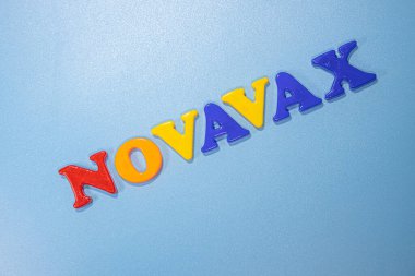 Novavax Şirketi logosu. Eğik ve değişken çocuklar için antivirüs adı verilen mektuplar. Yüksek açılı fotoğraf, yumuşak odak.