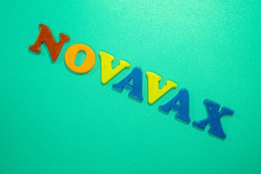 Novavax Şirketi logosu. Eğik ve değişken çocuklar için antivirüs adı verilen mektuplar. Yüksek açılı fotoğraf, yumuşak odak.