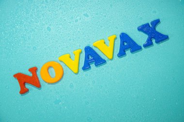 Novavax Şirketi logosu. Eğik ve değişken çocuklar için antivirüs adı verilen mektuplar. Yüksek açılı fotoğraf, yumuşak odak.