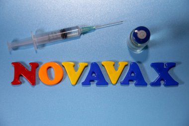 Novavax Şirketi logosu. Eğik ve değişken çocuklar için antivirüs adı verilen mektuplar. Yüksek açılı fotoğraf, yumuşak odak.