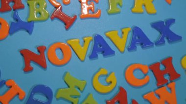 Novavax Şirketi logosu. Eğik ve değişken çocuklar için antivirüs adı verilen mektuplar. Yüksek açılı fotoğraf, yumuşak odak.